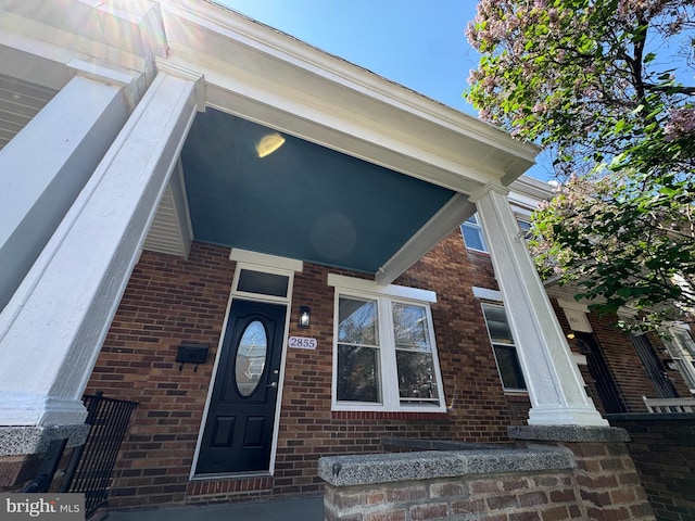 view of exterior entry with brick siding