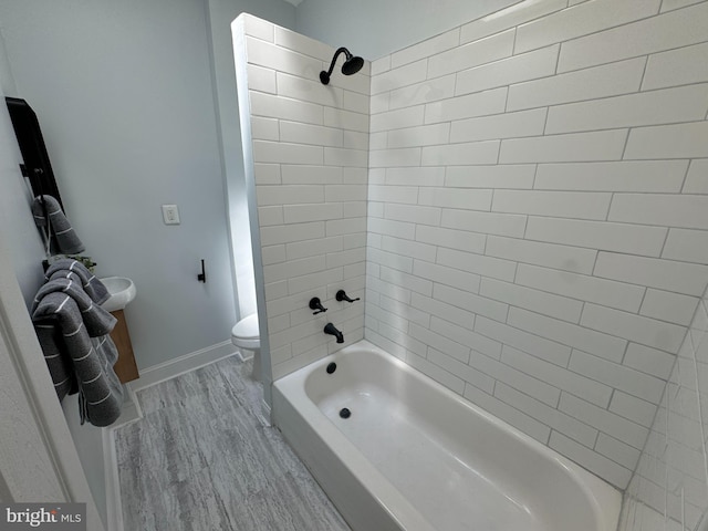full bathroom with baseboards, shower / bathing tub combination, toilet, and wood finished floors