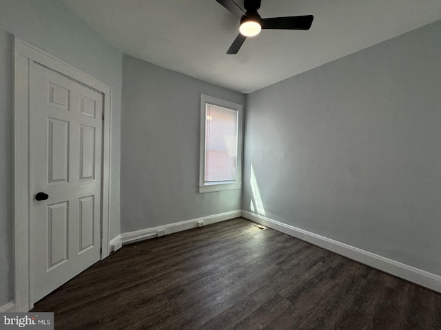 unfurnished bedroom with baseboards, dark wood-style floors, and ceiling fan