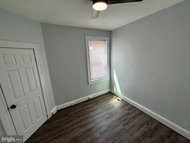 unfurnished bedroom with a ceiling fan, baseboards, visible vents, and dark wood finished floors