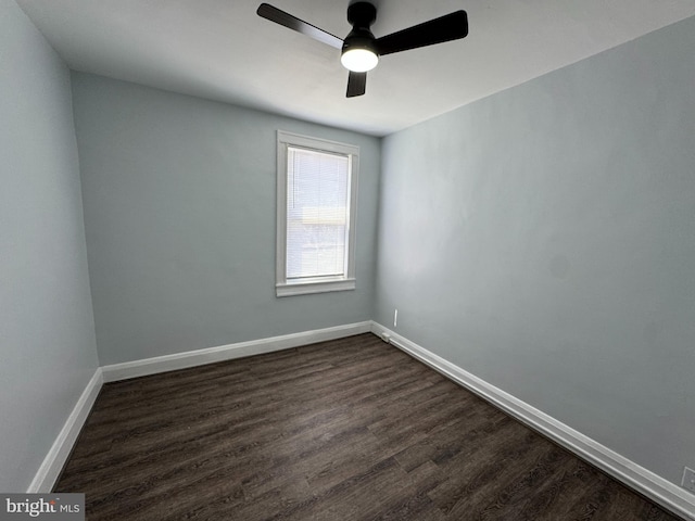 unfurnished room featuring a ceiling fan, baseboards, and dark wood finished floors