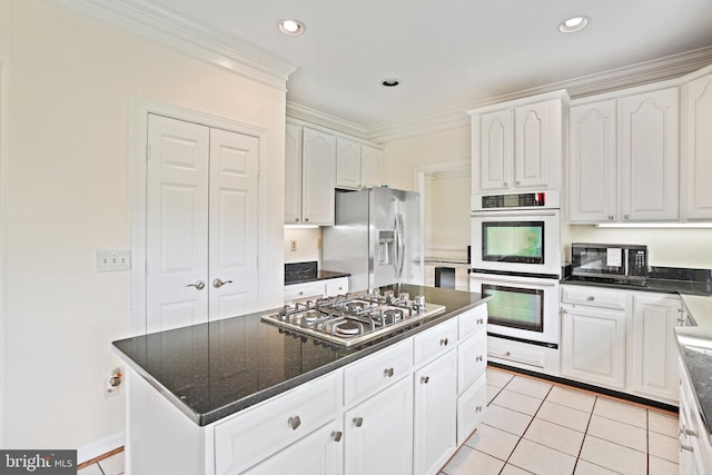 8233 Gallery Ct, Gaithersburg, MD 20886 - kitchen with appliances with stainless steel finishes, white cabinets, crown molding, a center island, and light tile patterned flooring