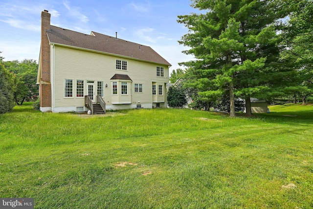 8233 Gallery Ct, Gaithersburg, MD 20886 - rear view of house with a chimney, entry steps, and a lawn