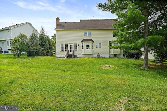 8233 Gallery Ct, Gaithersburg, MD 20886 - back of house with entry steps, a chimney, and a lawn
