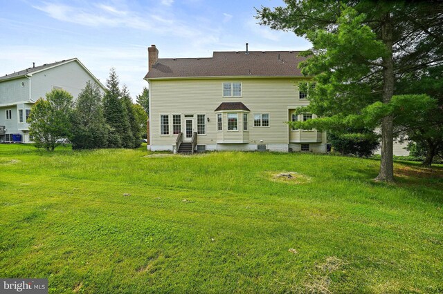 8233 Gallery Ct, Gaithersburg, MD 20886 - back of house with entry steps, a chimney, and a lawn