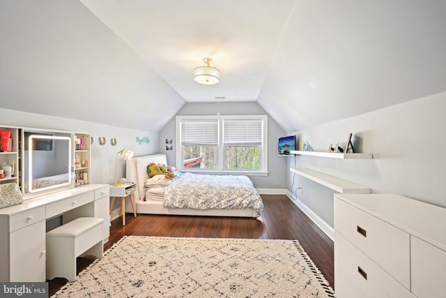bedroom with baseboards, lofted ceiling, and dark wood-style floors