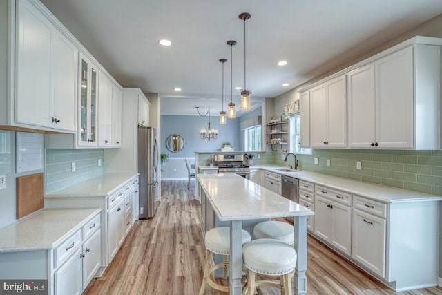 kitchen featuring a sink, white cabinets, appliances with stainless steel finishes, and light wood finished floors