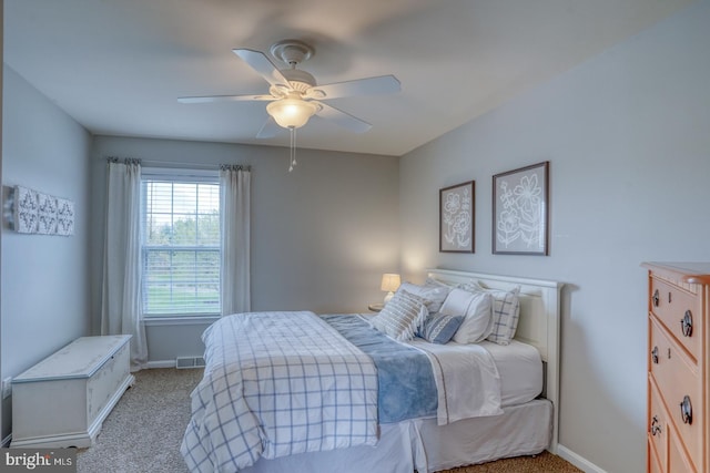 bedroom featuring visible vents, baseboards, a ceiling fan, and light colored carpet