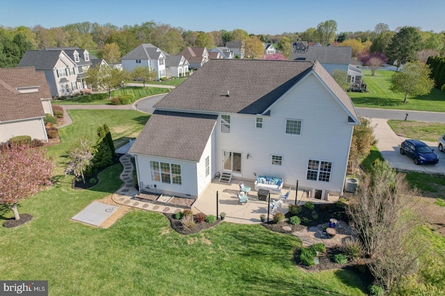 back of house featuring a residential view, roof with shingles, outdoor lounge area, a lawn, and a patio