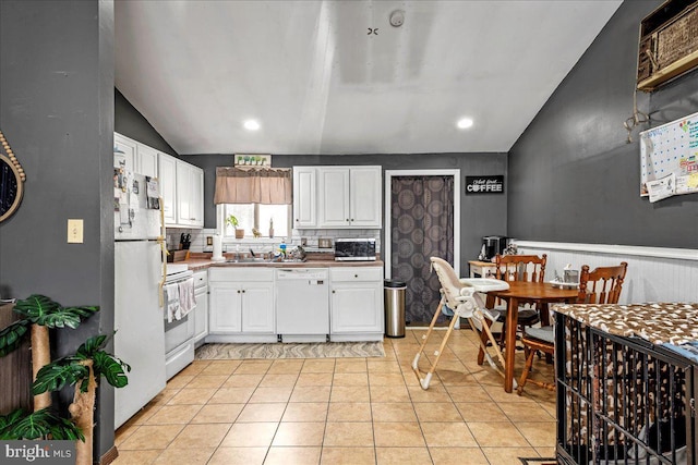 7443 Tamara Ln, Tobyhanna, PA 18466 - kitchen featuring white cabinets, light tile patterned flooring, white appliances, and vaulted ceiling