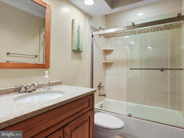 full bathroom with combined bath / shower with glass door, vanity, and toilet