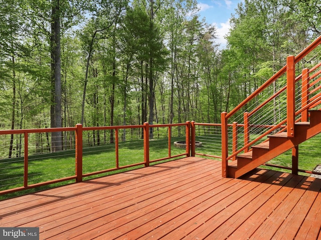 wooden deck with a lawn, stairs, and a fenced backyard