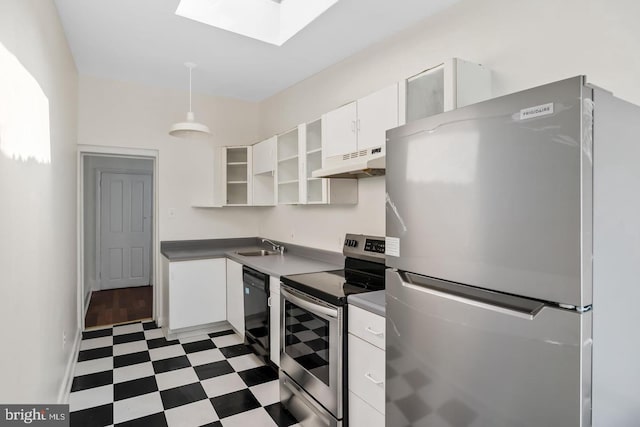 kitchen featuring white cabinets, a skylight, under cabinet range hood, stainless steel appliances, and tile patterned floors