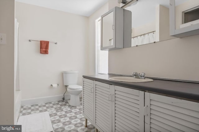 full bathroom featuring tile patterned floors, vanity, baseboards, and toilet