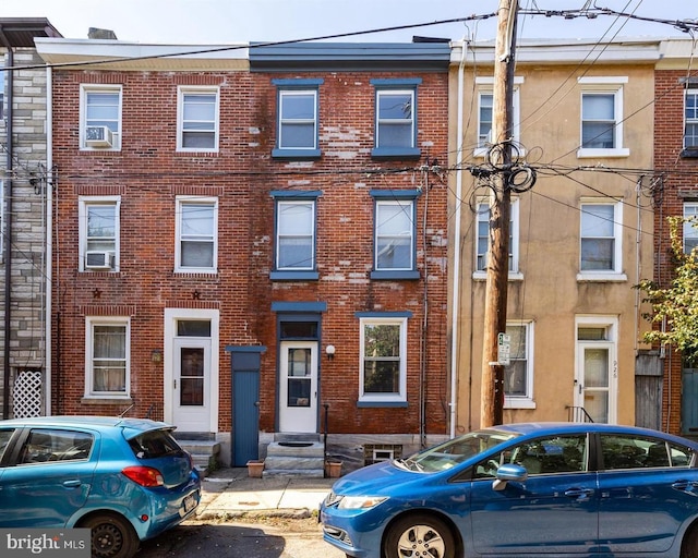 townhome / multi-family property featuring entry steps and brick siding