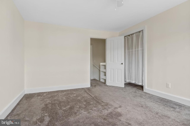 unfurnished bedroom featuring baseboards, ceiling fan, and carpet