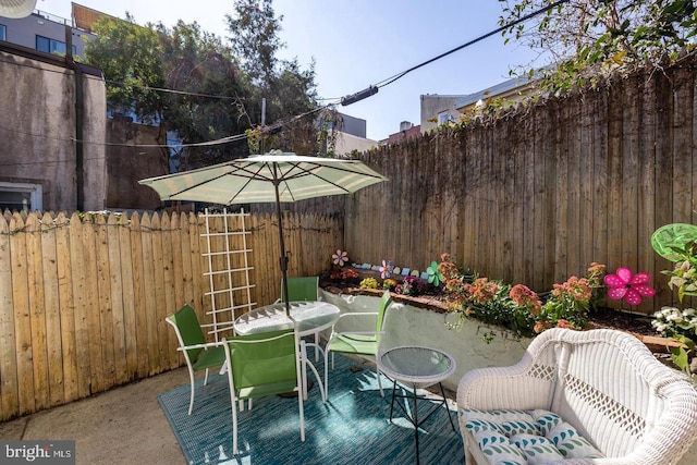 view of patio with a fenced backyard and outdoor dining area
