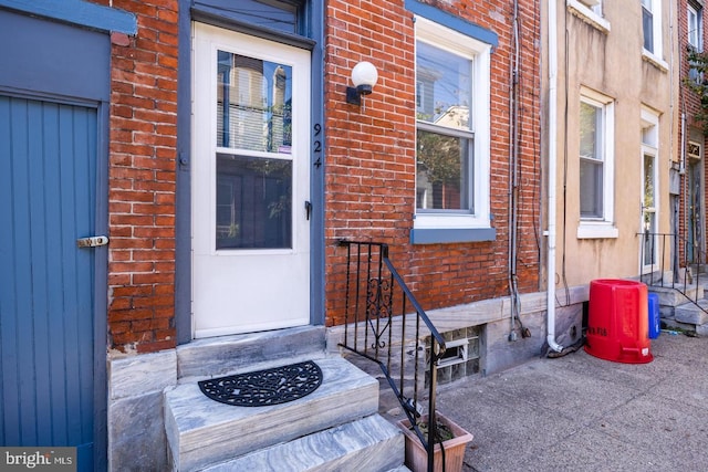 entrance to property featuring brick siding