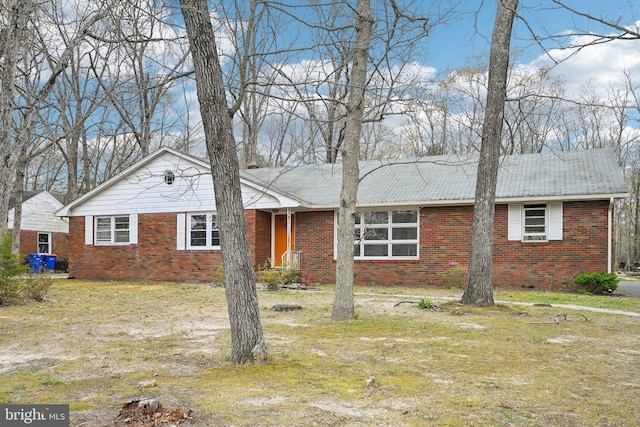 ranch-style house featuring brick siding and a front yard