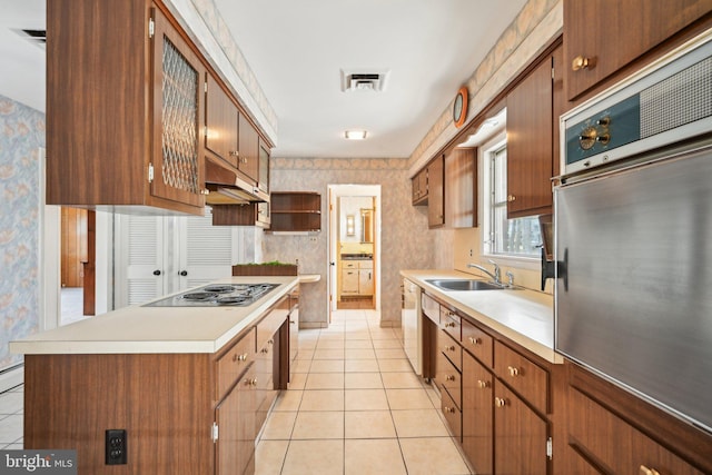 kitchen featuring wallpapered walls, visible vents, a sink, light tile patterned flooring, and appliances with stainless steel finishes