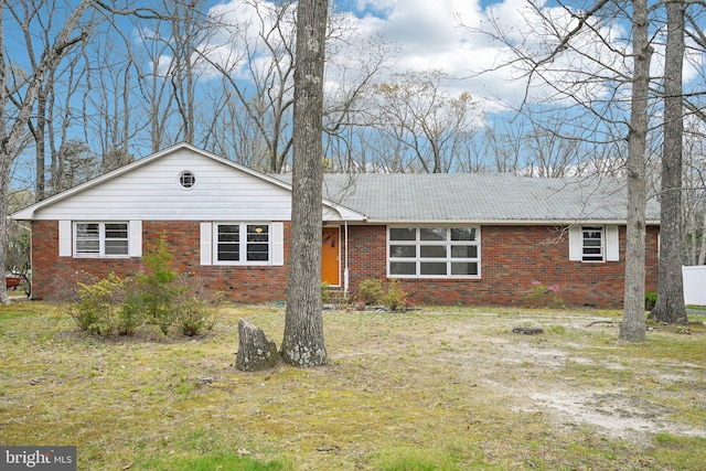 ranch-style home featuring brick siding and a front yard