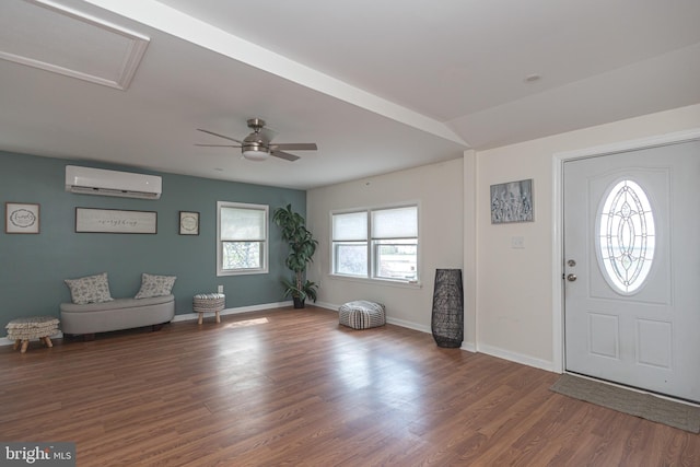 foyer with baseboards, a ceiling fan, wood finished floors, and a wall unit AC