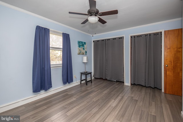 unfurnished bedroom featuring ornamental molding, baseboards, a ceiling fan, and wood finished floors