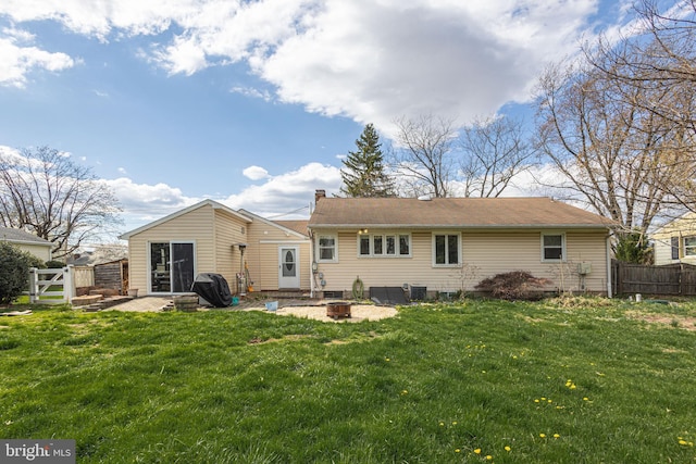 back of property with a patio area, an outdoor fire pit, fence, and a lawn