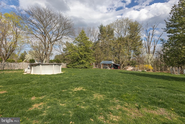 view of yard featuring fence and a covered pool