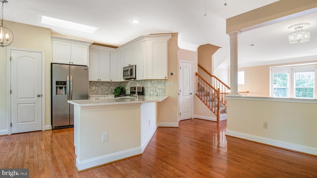 2080 Capstone Cir, Herndon, VA 20170 - kitchen with stainless steel appliances, tasteful backsplash, light countertops, white cabinets, and light wood-type flooring