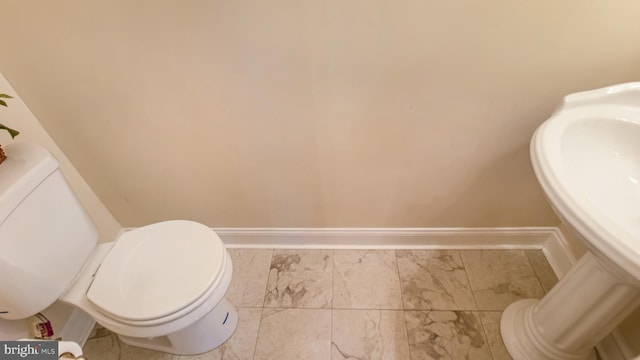 2080 Capstone Cir, Herndon, VA 20170 - half bathroom with toilet, baseboards, and marble look tiles