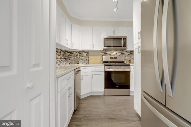 kitchen with a sink, light countertops, stainless steel appliances, and white cabinetry