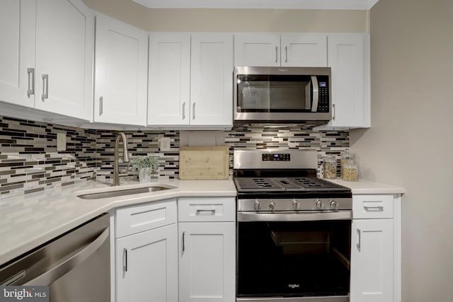 kitchen with a sink, tasteful backsplash, stainless steel appliances, and white cabinetry
