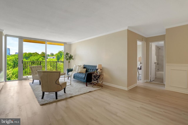 sitting room featuring crown molding, expansive windows, and wood finished floors