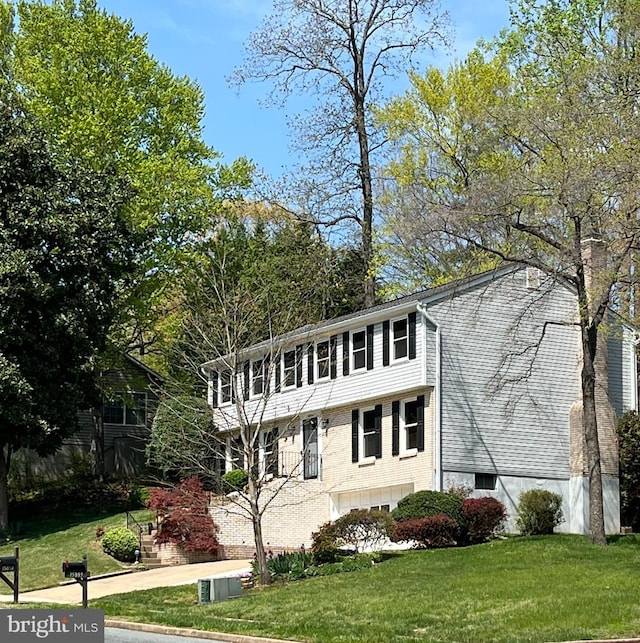 view of front of property featuring a front lawn, brick siding, and a garage