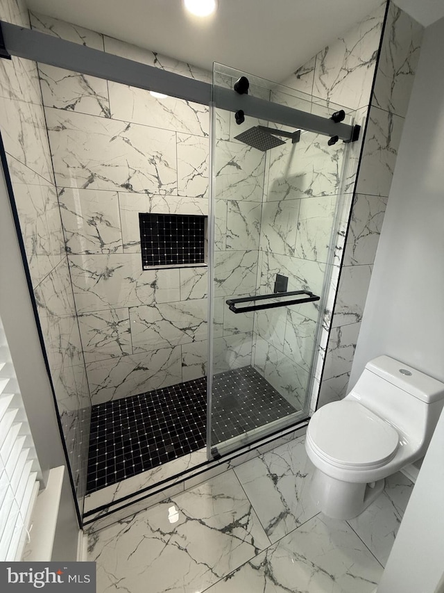 bathroom with toilet, marble finish floor, and a marble finish shower