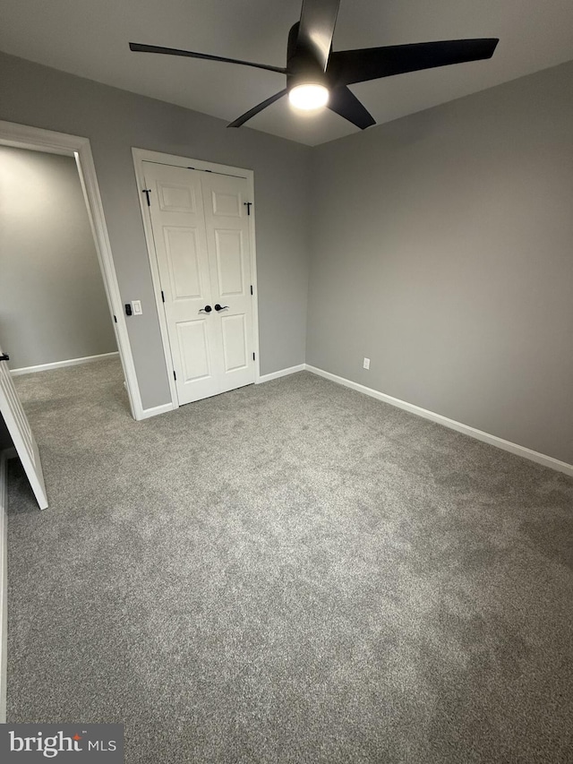 unfurnished bedroom featuring carpet floors, baseboards, a closet, and ceiling fan