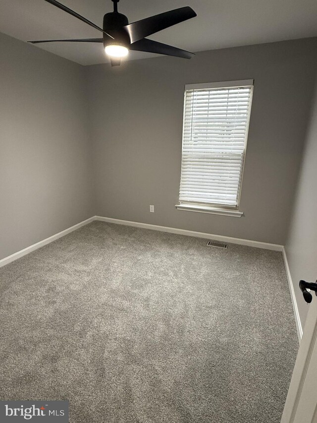 carpeted empty room with baseboards and ceiling fan