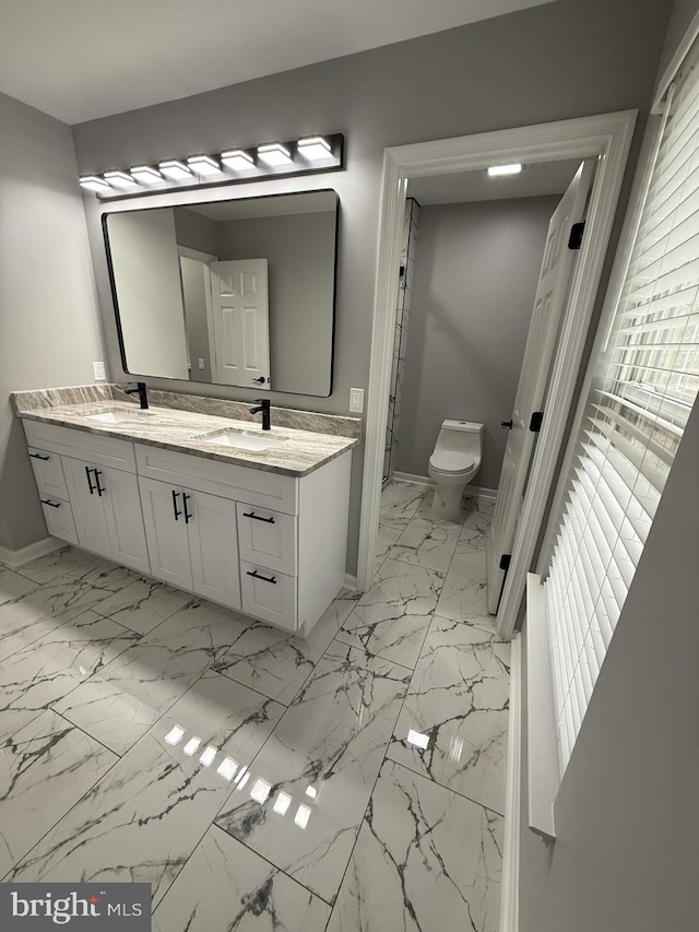 full bathroom featuring a sink, baseboards, marble finish floor, and toilet