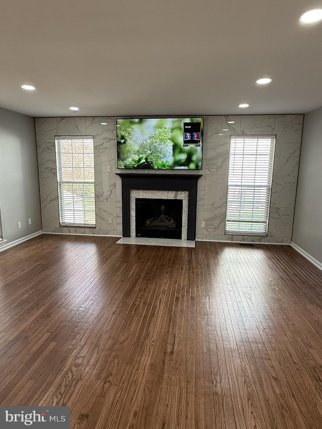 unfurnished living room with a fireplace, wood-type flooring, and recessed lighting