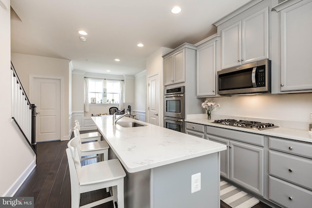 6645 Rhode Island Ave, Riverdale, MD 20737 - kitchen featuring dark wood-style floors, an island with sink, a sink, gray cabinetry, and appliances with stainless steel finishes