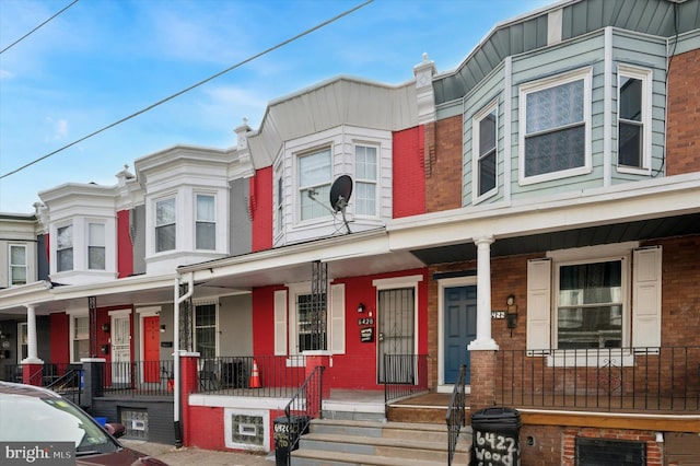 townhome / multi-family property featuring covered porch