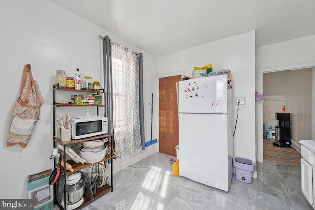 kitchen featuring white appliances and marble finish floor