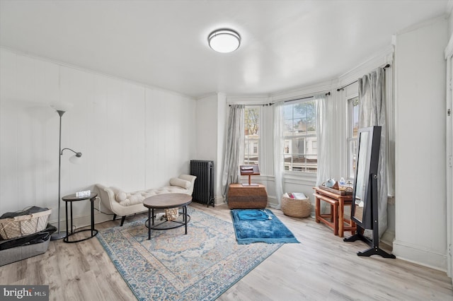 living area with light wood-type flooring and radiator
