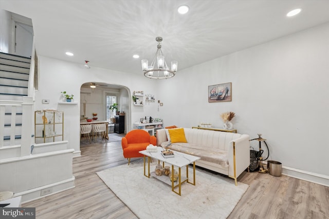 living room with recessed lighting, arched walkways, stairs, and wood finished floors