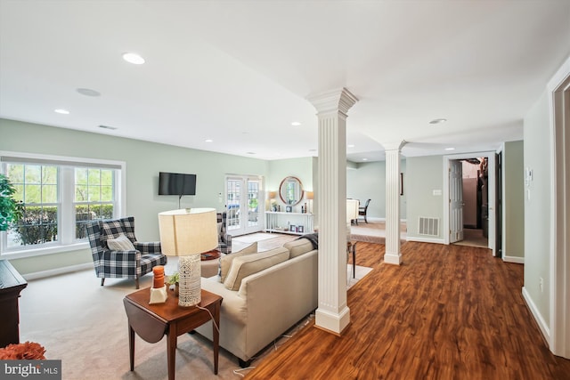 living room featuring visible vents, baseboards, decorative columns, recessed lighting, and wood finished floors