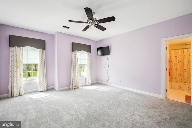 empty room with carpet floors, baseboards, a ceiling fan, and visible vents