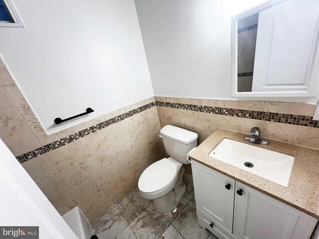 1447 Holbrook St NE, Washington, DC 20002 - bathroom featuring toilet, vanity, a wainscoted wall, and tile walls