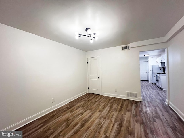 1447 Holbrook St NE, Washington, DC 20002 - spare room with dark wood-style flooring, a chandelier, and baseboards