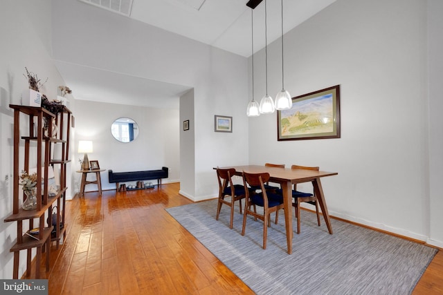 dining room featuring visible vents, light wood finished floors, and baseboards